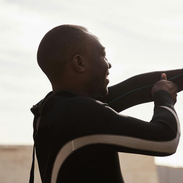Silhouette of a man stretching at sunrise, suggesting energy and a fresh start.